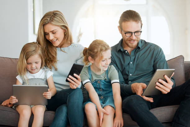 istock Shot of a young family sitting on the sofa together and bonding while using technology 1372309669
