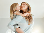 Shot of an attractive young woman bonding with her daughter and giving her a piggyback ride at home