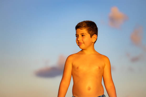 Cute kid walking on the beach at sunset