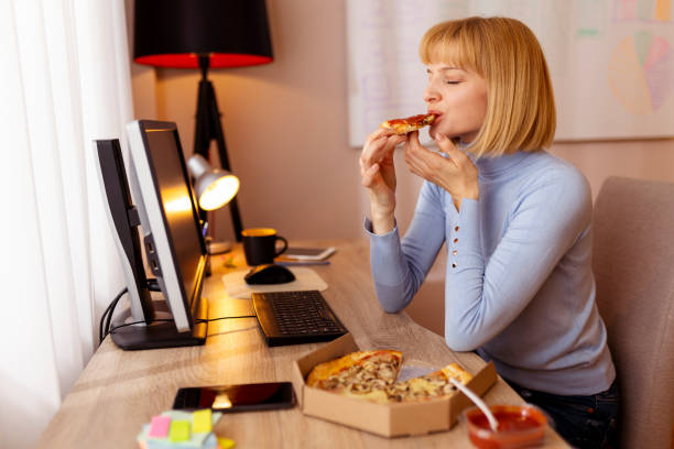 istock Woman taking a lunch break eating pizza 1372315308