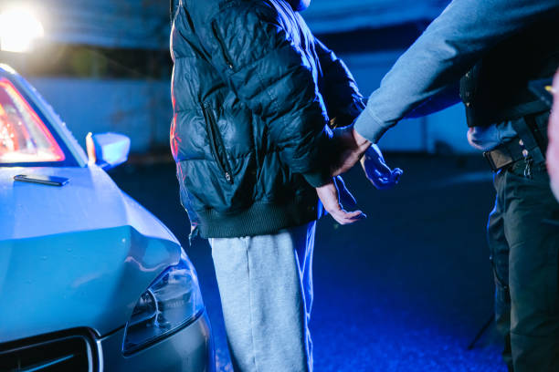 istock Task force officer putting a handcuffs on suspect's hands by the car 1372319867