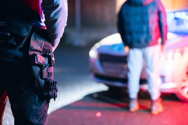 istock Policeman investigating a young suspect standing by the car 1372320669