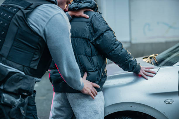 istock Policeman searching a young criminal for illegal things 1372320823