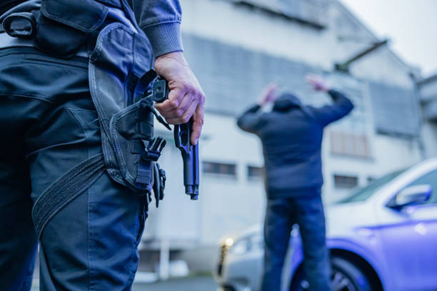 istock Policeman holding a pistol while arresting a suspect 1372320898
