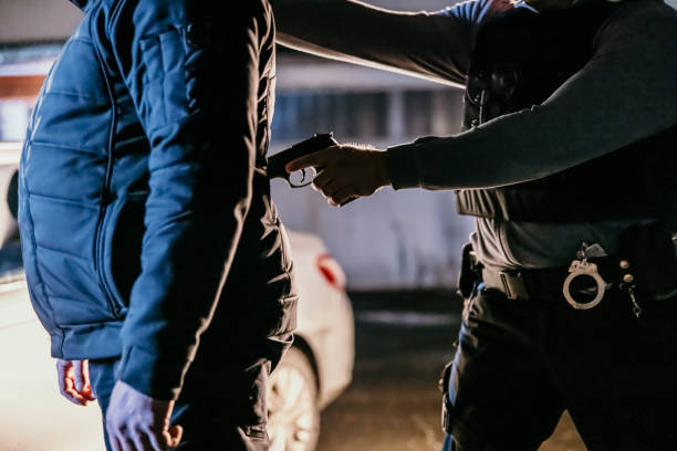 istock Police officer aiming a gun to a suspect's back 1372320940