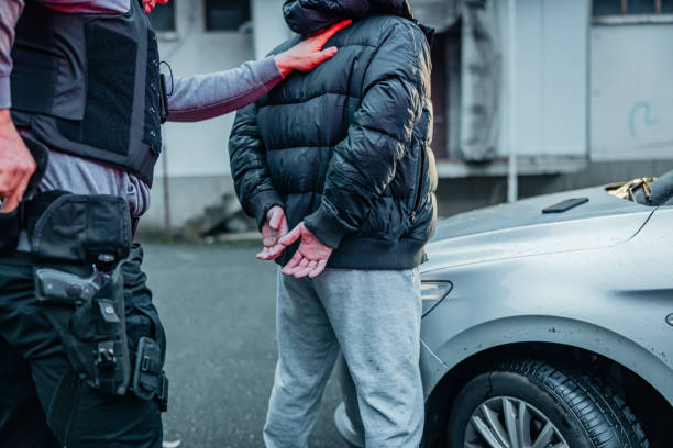 polizist bei der festnahme eines jungen gangsters am auto - gun men handgun spy stock-fotos und bilder