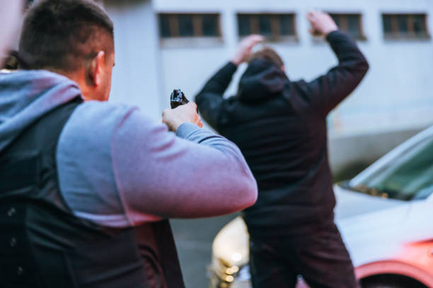 istock Policeman aiming a gun to a surrendering suspect 1372321427