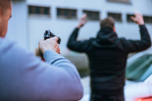 istock Policeman aiming a handgun to a surrendering suspect 1372321468