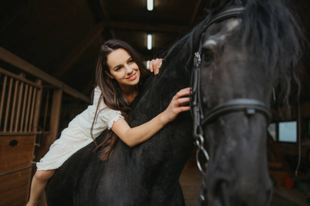 istock Happy young woman stroking while lying on horseback 1372323425