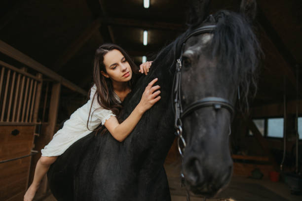 istock Young woman stroking while lying on horseback 1372323453