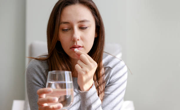 istock Young woman taking medication at home 1372323464