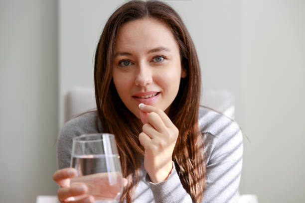 istock Young woman taking medication at home 1372323465