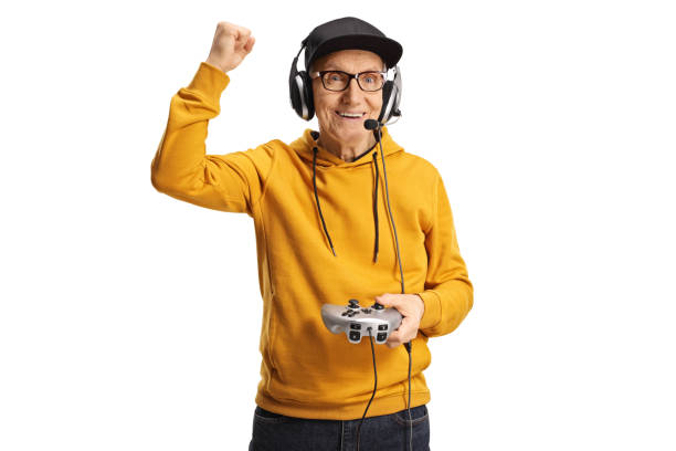 Happy elderly man with headphones and joystick gesturing win isolated on white background