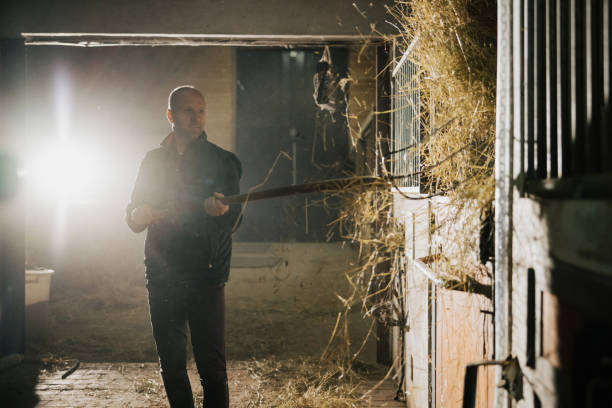 istock Mid adult man throwing hay with pitchfork 1372325208