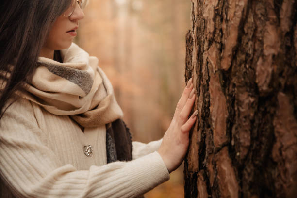 istock Young woman touching a tree trunk 1372327012