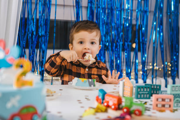 istock Little boy eating birthday cake. 1372329388