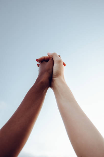 istock African American and caucasian race holding hands 1372330362
