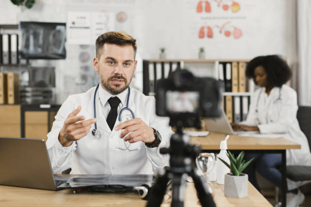 istock Qualified doctor using laptop and camera for recording video 1372330528