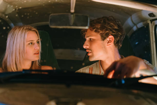 istock Young couple looking at each other while sitting in car during date 1372330826