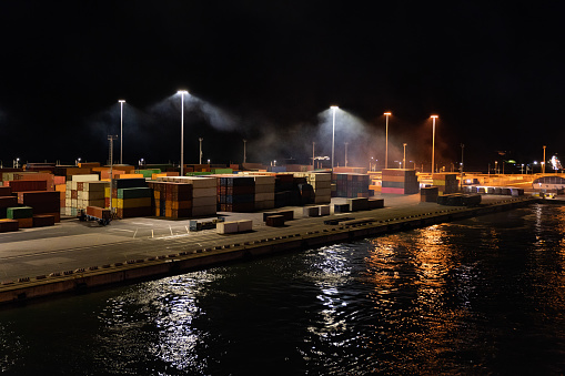 Night view of an international port, transportation and logistics unloading