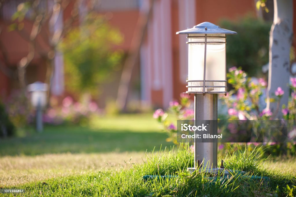 Outdoor lamp on yard lawn for garden lighting in summer park Outdoor lamp on yard lawn for garden lighting in summer park. Garden Stock Photo
