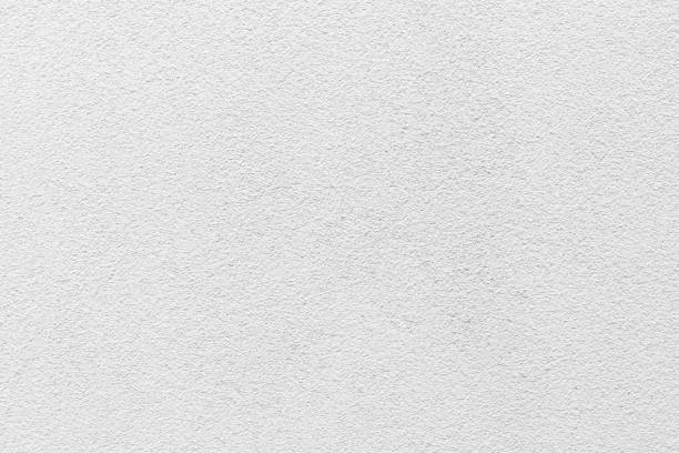 istock Sample of a texture of white plaster. Wall finished with a decorative cement stucco. Example of exterior building decoration. Clean uniform grainy background. Banner. Wallpaper. Copy space. Pattern 1372336066