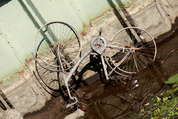 bicicleta vieja y oxidada que yace en el lecho de un río - vergessen fotografías e imágenes de stock