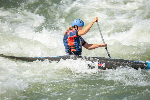 Great Britain canoe slalom athlete paddles across white water
