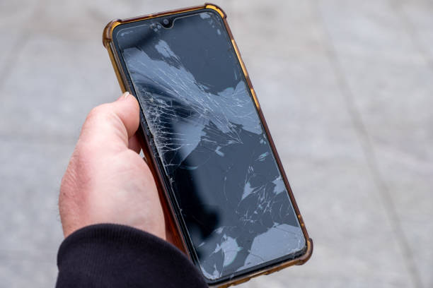 istock a man holding a phone with a broken screen 1372337710