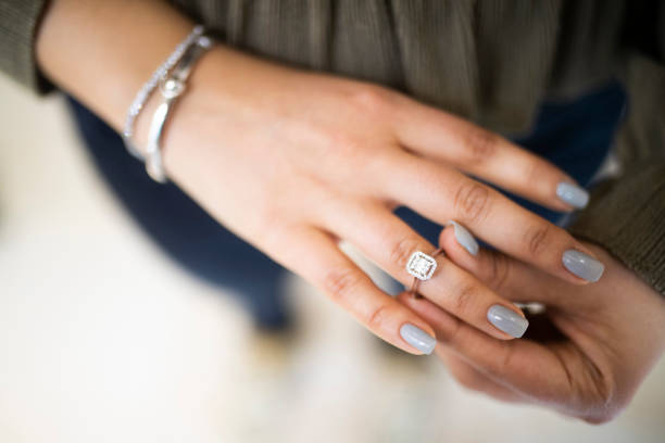 A detailed close-up of a stunning silver solitaire ring featuring a sparkling diamond centerpiece, elegantly displayed among other jewelry pieces in a luxury setting.