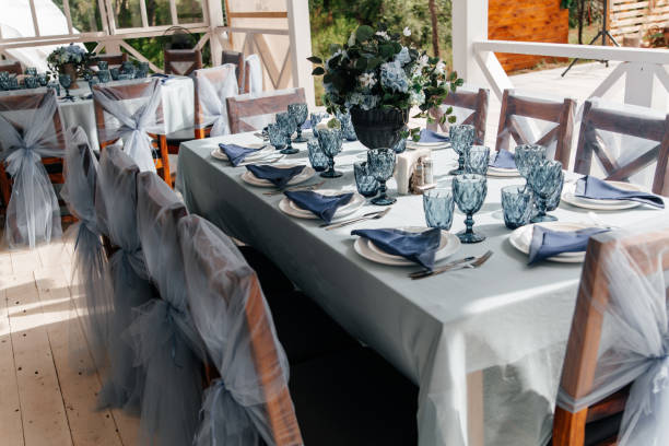 istock Blue glasses, plates and utensils on a festive table with flowers. 1372339379