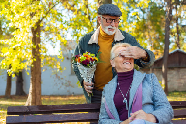 Senior man surprised his wife with flowers stock photo