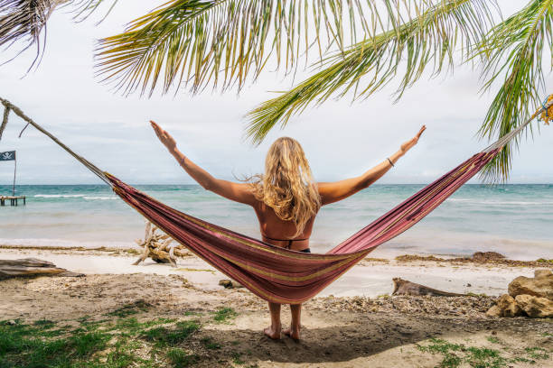 istock Happy woman relaxing in hammock 1372341243