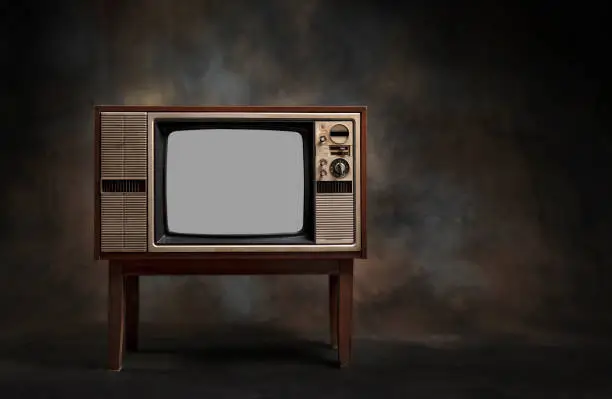 Photo of Retro old television (TV) standing on a dark background
