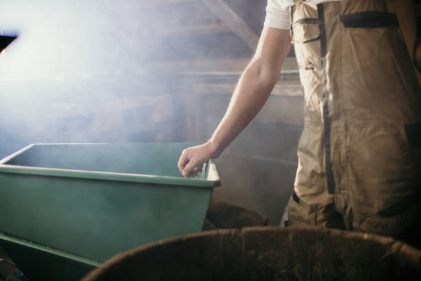 istock Male farmer leaning on hopper beside barrel 1372347276