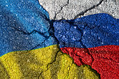 Ukraine und Russland Flaggen mit Rissen, politischer Konflikt.