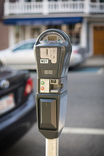 View of a park meter in use in a neighborhood street.