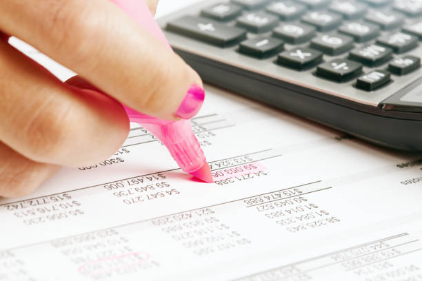 Close-up of female accountant or auditor's hand working on corporate financial figures.