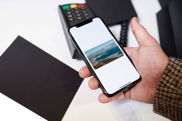istock A close-up hand which is holding a smartphone while paying using NFC in a store. 1372351888
