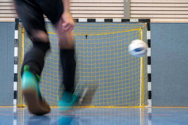 garçon jouant au football dans une salle de sport - soccer child indoors little boys photos et images de collection