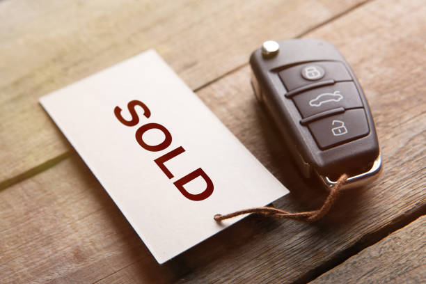 Car auction Sold out concept. Vehicle security key with tag on the wooden background stock photo