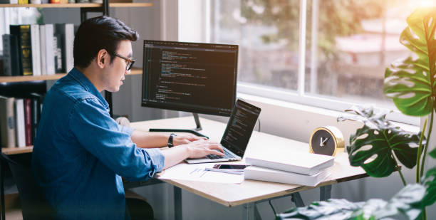 オフィスで働く若いアジアのプログラマー - デスクトップ型パソコン ストックフォトと画像