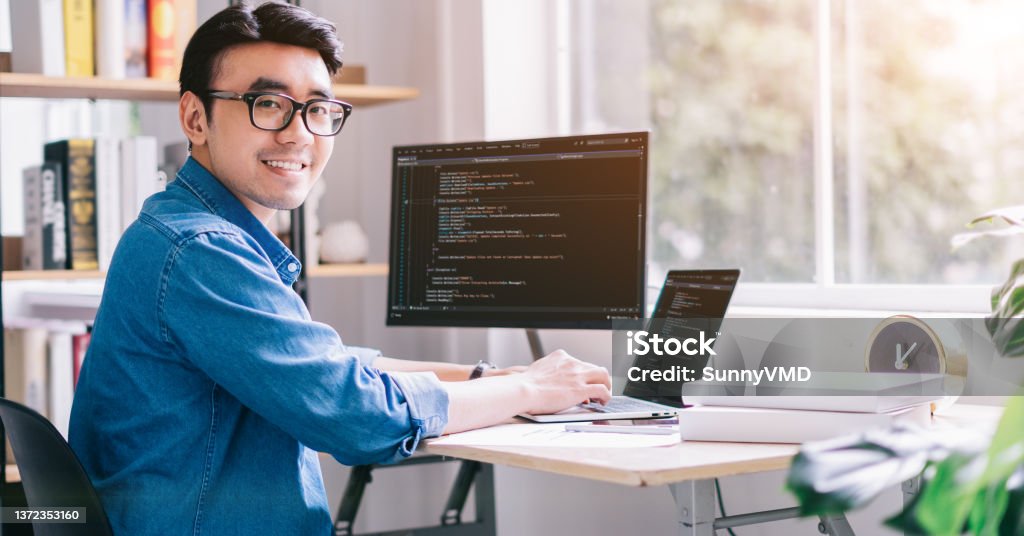 Young Asian programmer working at office Computer Programmer Stock Photo