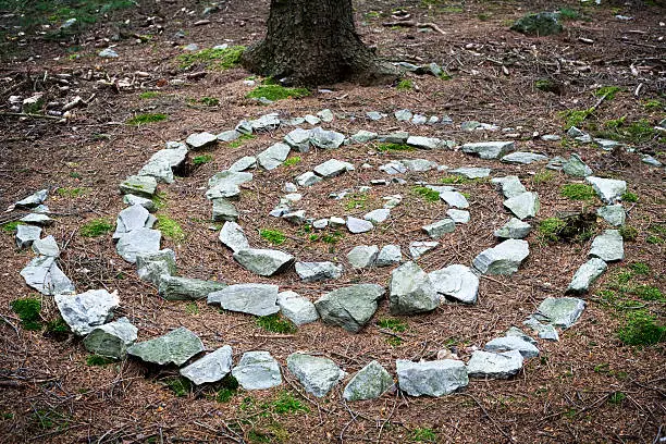 Celtic rune made out of stones in the forest - spiral