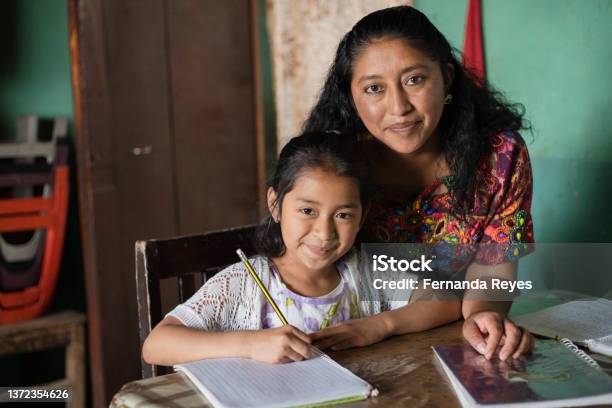 Hispanic Mom Helping Her Little Daughter Do Her Homework Mom Teaching Her Daughter To Read And Write At Home Mayan Family At Home Stock Photo - Download Image Now