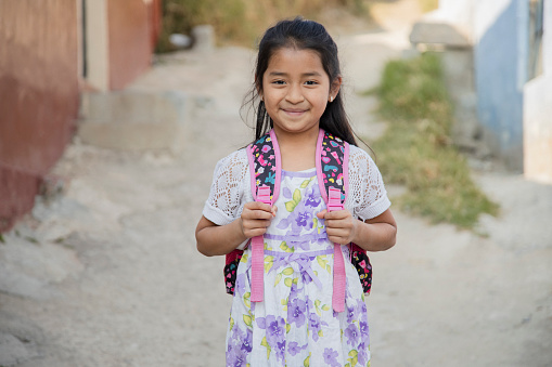 Hispanic girl ready to go to school in rural area - Latin girl on her way to school - Happy Mayan girl in the village