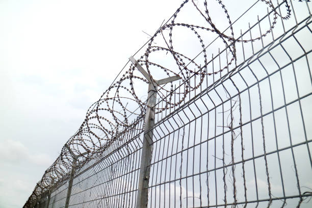 istock Wire Fence Airport with white sky 1372354772