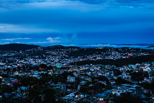 downtown city night view with lighting and dramatic cloudy sky at evening from mountain top image is taken at evening shillong meghalaya india.