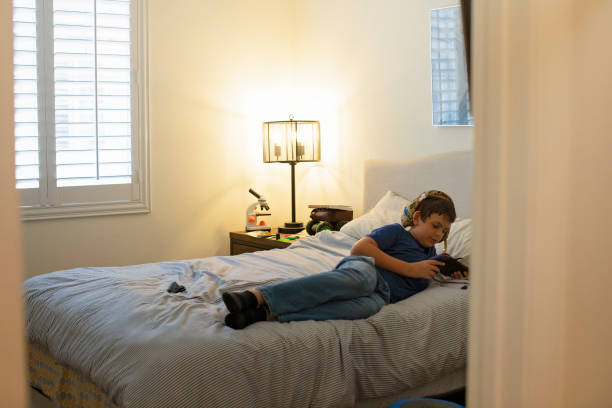 istock A teen boy plays a game on his bed 1372355724