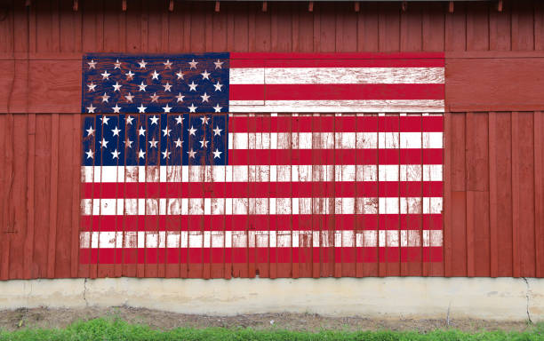 red barn wall american flag painted faded worn weathered farmland heartland america symbol patriotism building stock photo